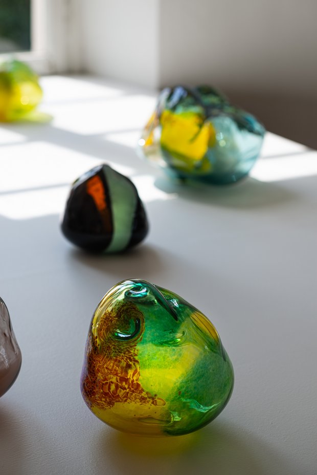 Kleine biomorph geformte Glaskörper in bunten Farben.