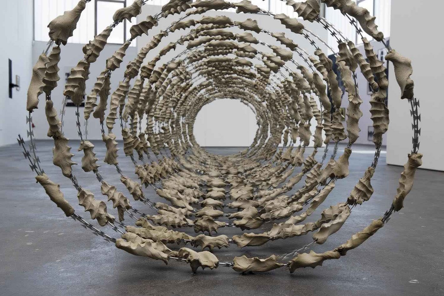 Eine Skulptur aus Maschendraht und Beton auf dem Boden eines Ateliers.