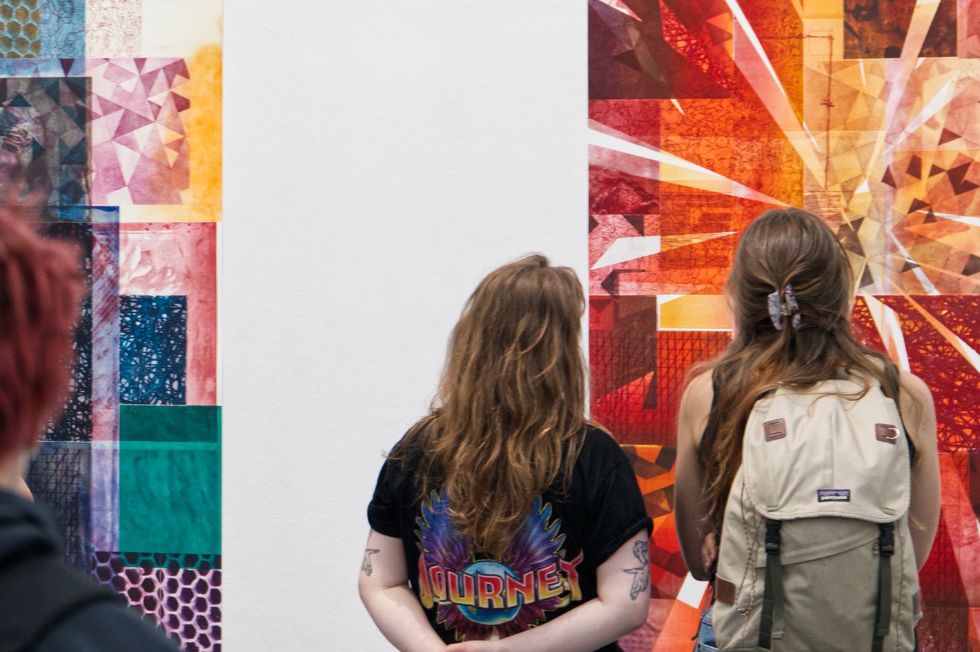 Zwei Besucherinnen stehen vor farbigen Drucken an der Wand. Foto: Gabriel Anastasescu.